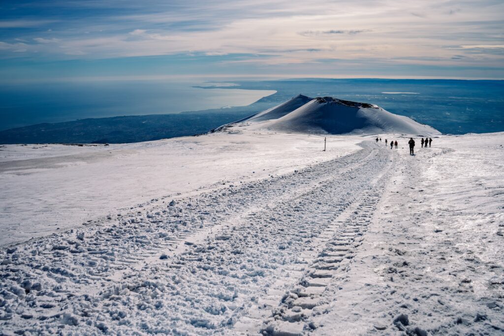 Vista panoramica etna innevata con turisti